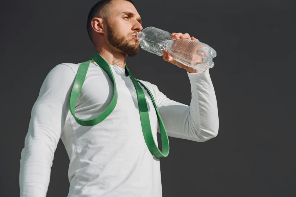 man drinking water to stay hydrated during fever recovery