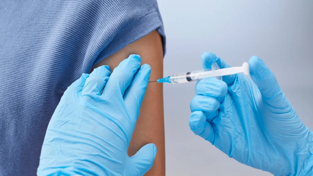 Healthcare worker giving measles vaccine injection in arm for disease prevention