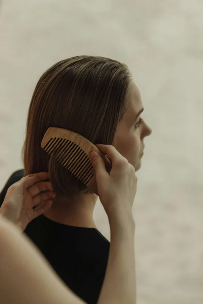 Can dandruff cause hair loss? Woman combing hair showing potential hair fall and scalp health issues