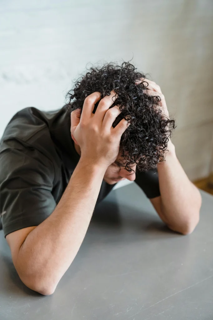 Can dandruff cause hair loss? Man holding head due to scalp itching and hair fall concerns