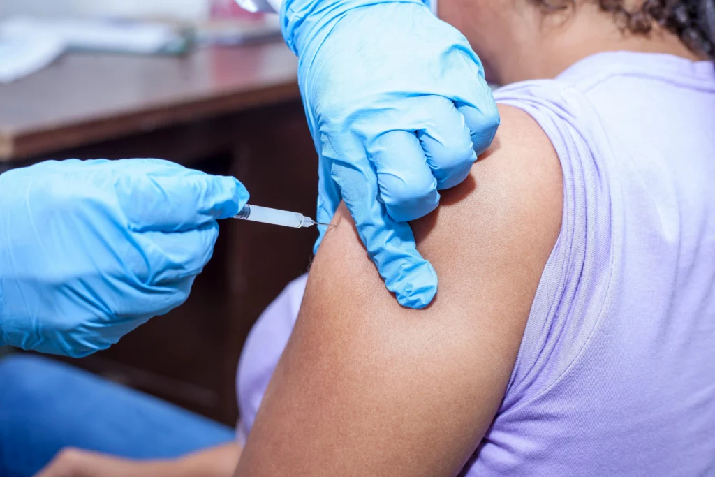 Doctor giving pneumonia vaccine injection in arm showing common side effects like soreness