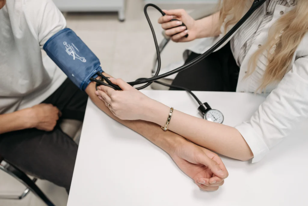 High blood pressure doctor checking blood pressure reading during a routine medical examination.
