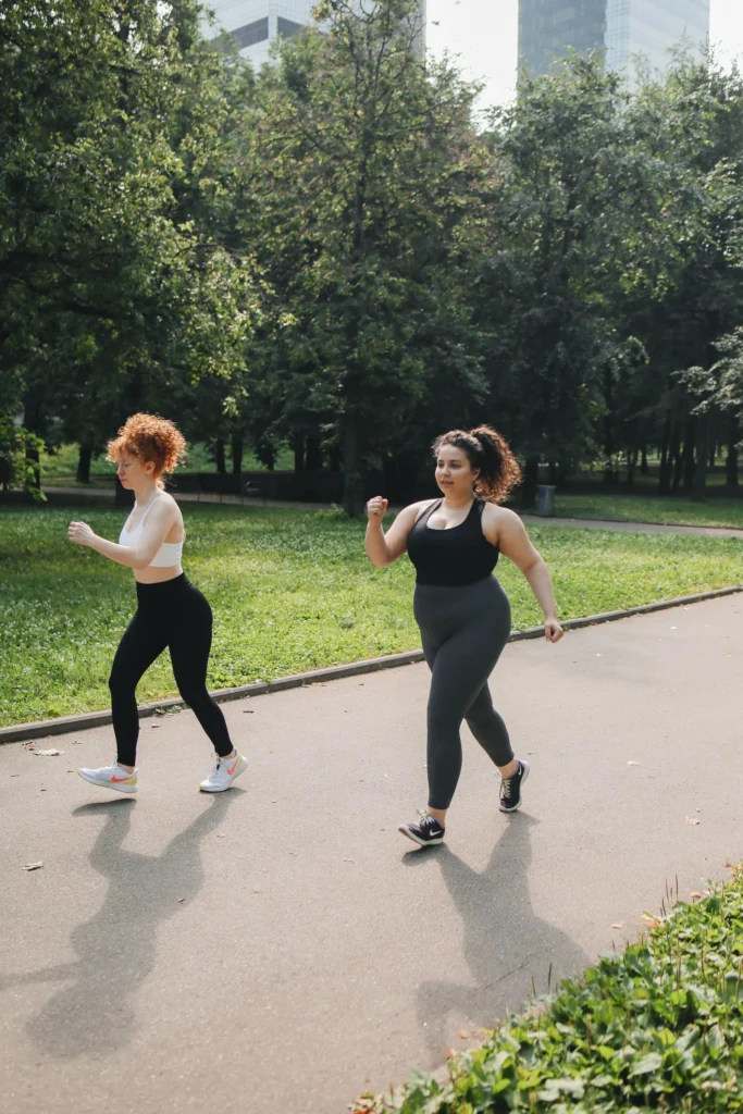 High blood pressure exercise with two women doing brisk walking in a park to support heart health