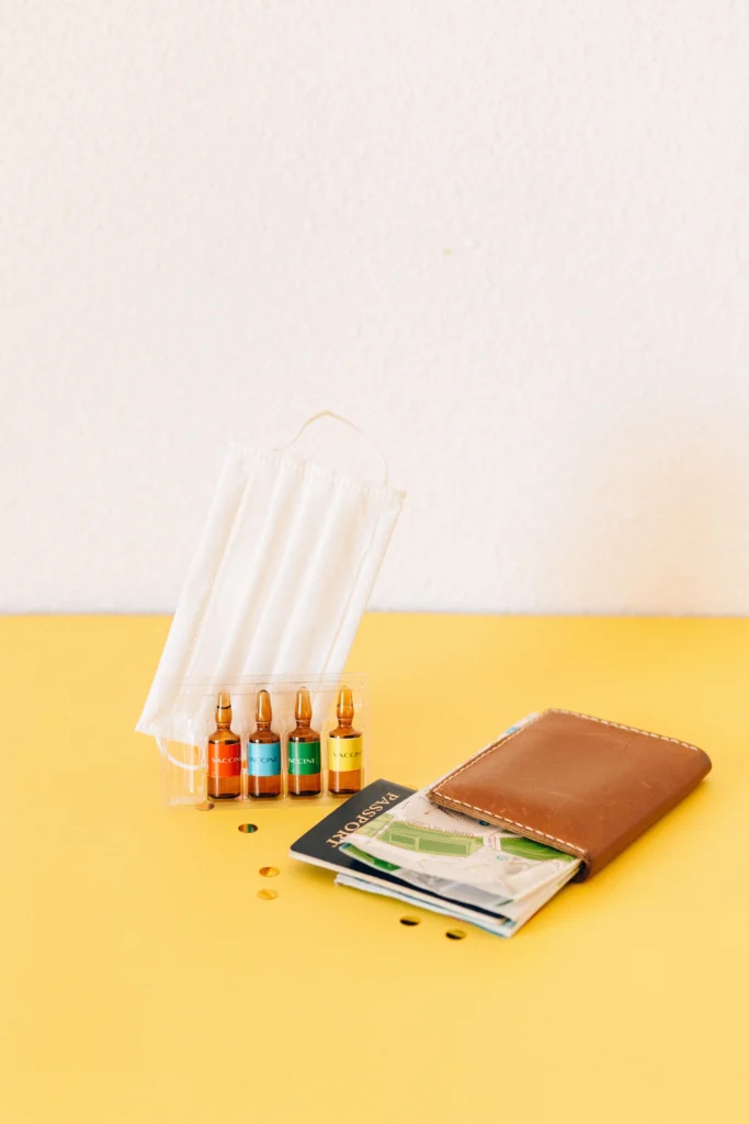 Yellow Fever Jab vaccine vials, face mask, and passport for international travel vaccination requirements