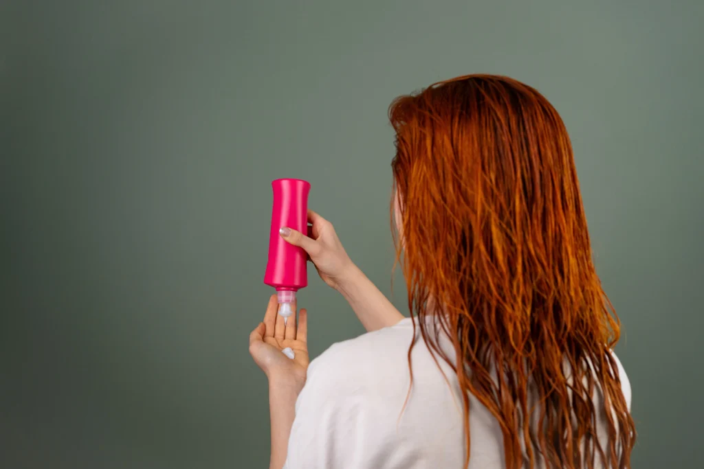 Person applying conditioner to wet hair as part of a healthy hair care routine for soft, smooth, and manageable hair