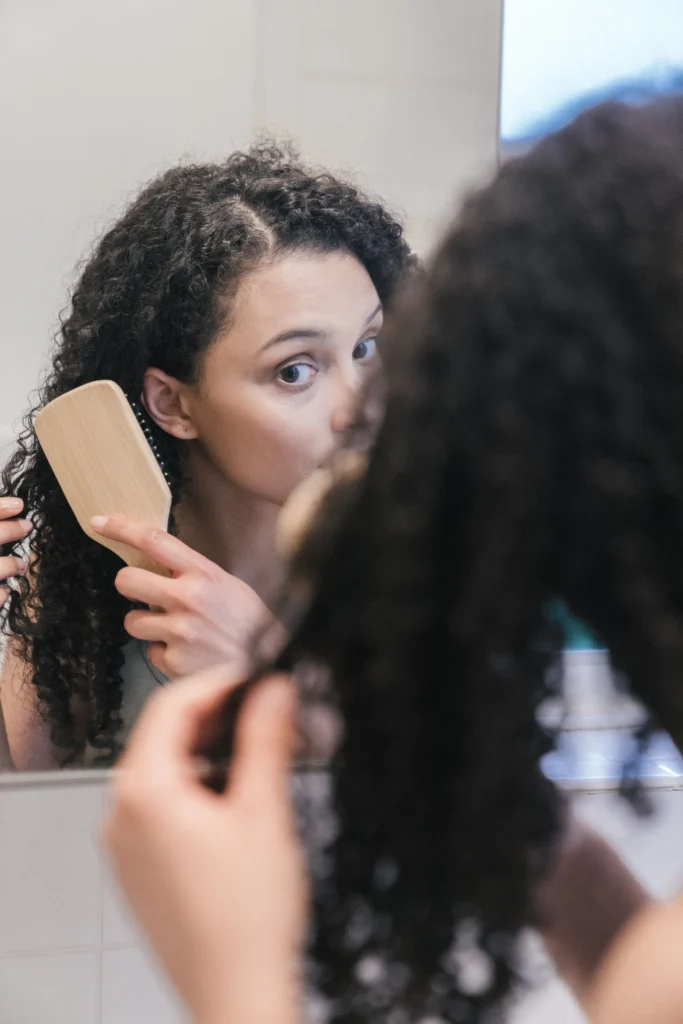 Woman with naturally curly hair before a keratin treatment for hair care, showing frizz and natural hair texture.